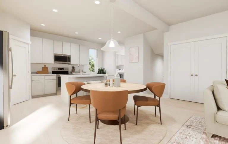 Bright, modern kitchen and dining area with white cabinets, stainless steel appliances, and a round wooden table. Light wood floors and neutral decor create a warm atmosphere—perfect for the inviting style found in many homes in Utah. Natural light fills the space.