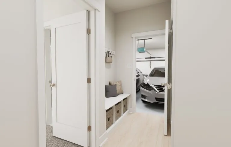 A hallway with light wood floors leads to a garage where a silver car is parked—typical of many homes in Utah. A white bench with cushions and storage baskets sits beneath wall hooks, where a purse hangs. Doors are open on both sides.